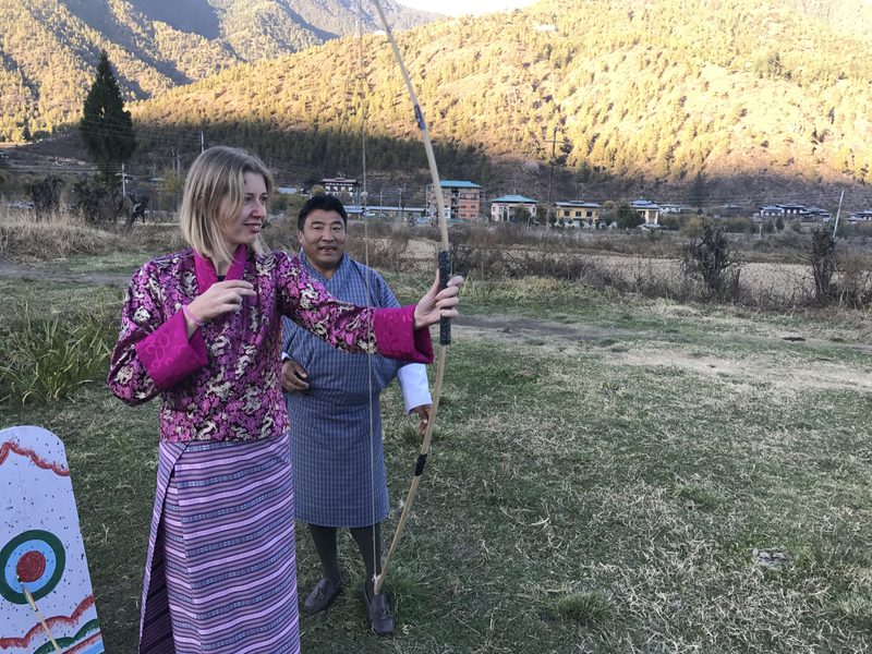 Touristin probiert BogenschieĂźen in Paro, Bhutan