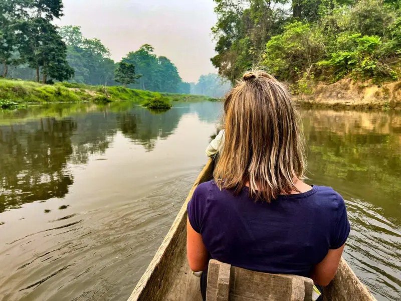 Touristin in Boot im Chitwan Nationalpark