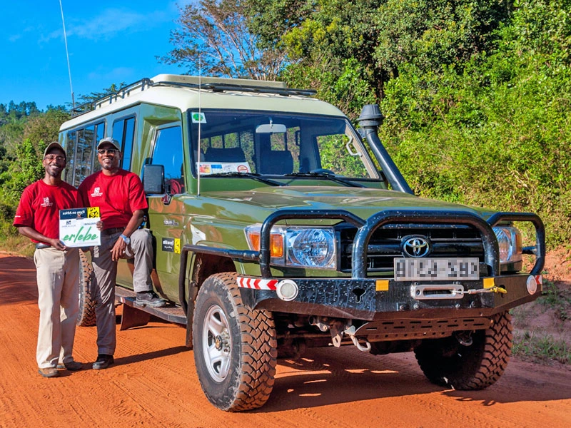 Locals vor einem Safarijeep in Tansania