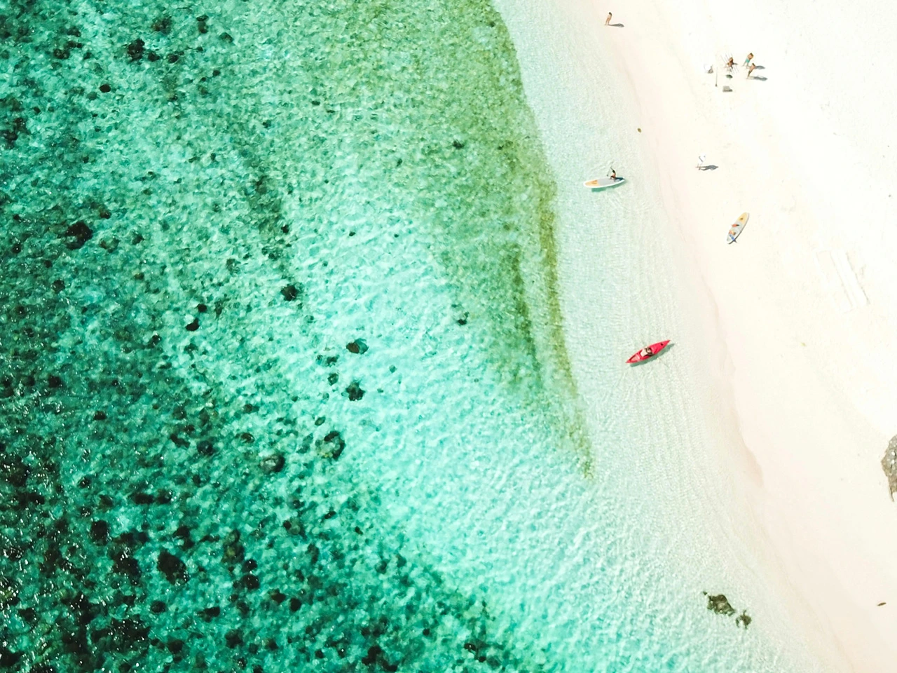 türkisfarbenes Meer mit Strand und Booten