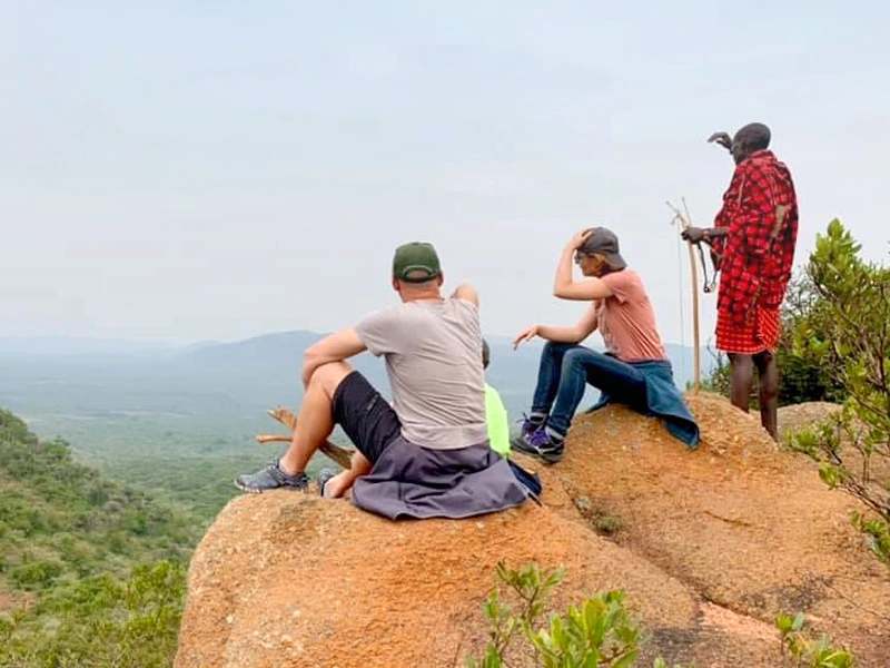 Masai und zwei Touristen genießen den Ausblick