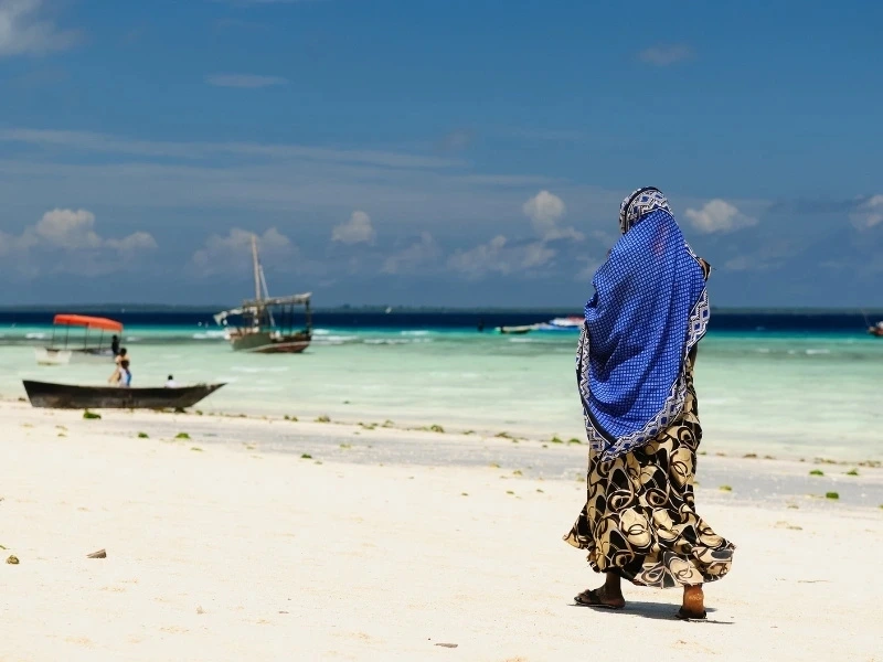 Frau am Strand auf Sansibar, Tansania