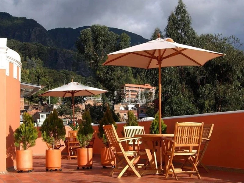 Terrasse eines Familienhotels in Bogotá, Kolumbien, die einen gemütlichen Außenbereich mit Sitzgelegenheiten und Blick auf die Stadt bietet.