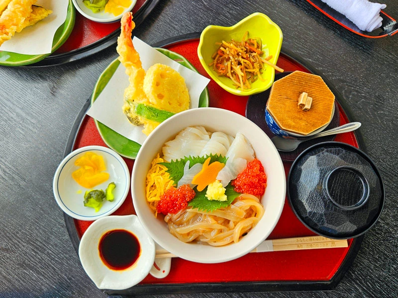 Tablett mit vielen verschiedenen traditionellen japanischen Speisen im Ryokan