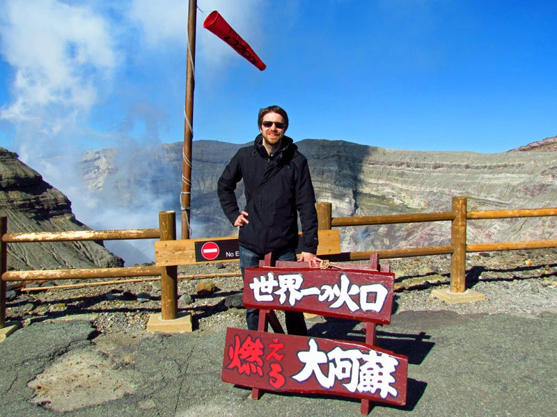 Reisender vor dem Krater des aktiven Aso Vulkan