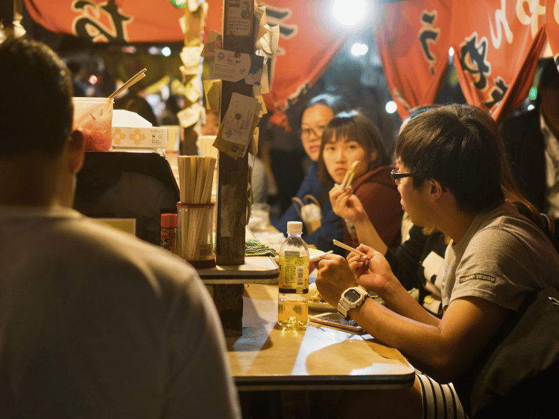 Menschen essen an einem Yatai Stand in Fukuoka