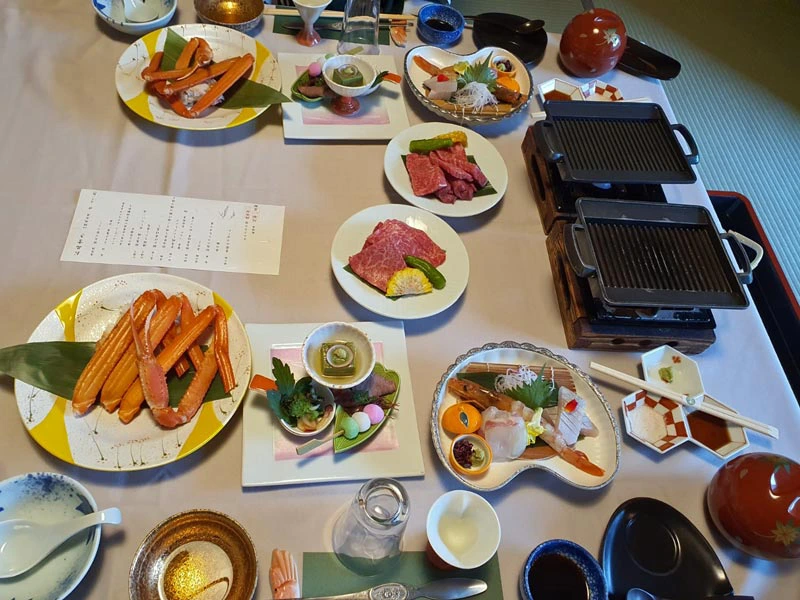 Festmahl mit Sushi, rohem Fleisch zum Grillen und Gemüse im Ryokan