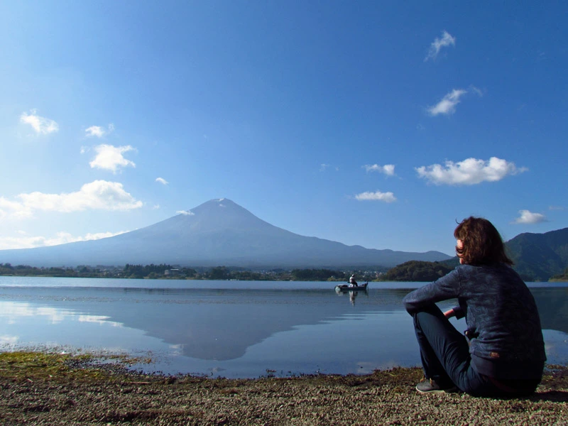 Reisende sitzt am Kawaguchiko See bei klarer Sicht auf den Mount Fuji in Japan