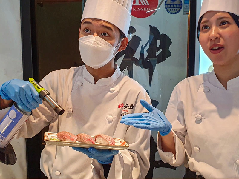 Köche flambieren Sushi in Osaka in Japan