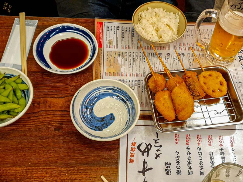 Snacks auf dem Tisch bei der Streetfood Tour in Osaka in Japan