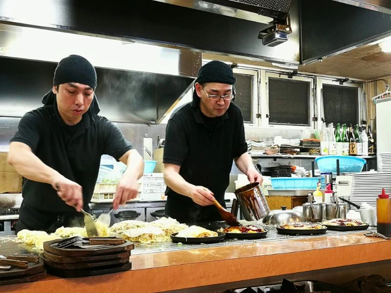 Zubereitung von Okonomiyaki in einer offenen Küche in Japan