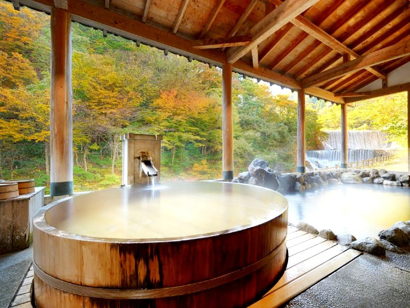 Onsen auf der Terasse am Fluss während der Herbstfärbung