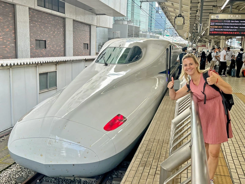 Reisende bei Einfahrt eines Shinkansen Zug am Bahnsteig in Tokyo