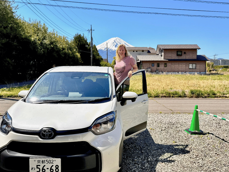 Frau mit Mietwagen beim Mt. Fuji