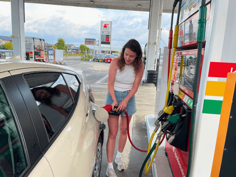 Frau tankt helles Auto in Japan