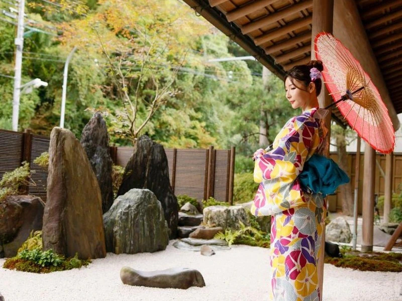 Frau im Kimono gekleidet vor Ryokan Unterkunft in Japan.