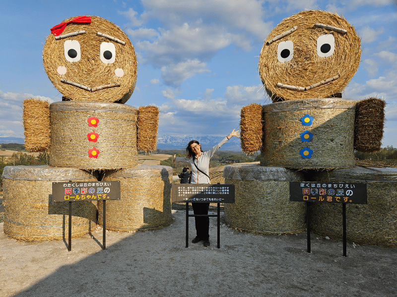 Frau vor Strohfiguren in Furano