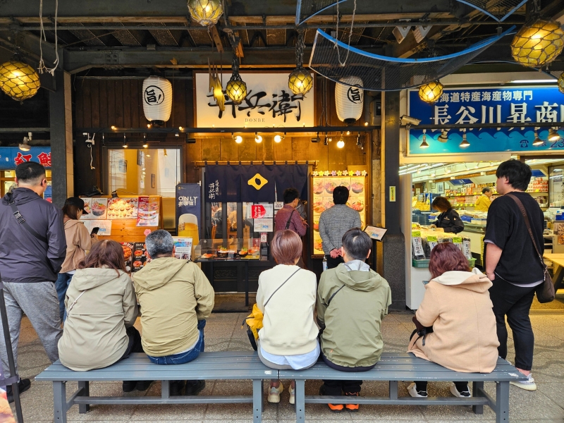 Menschen warten vor Restaurant auf dem Fischmarkt von Sapporo