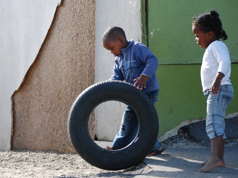Afrikanische Kinder rollen einen Autoreifen