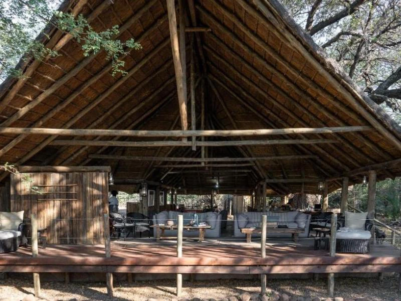 Botswana Sitzbereich mit einer großen überdachten Terrasse, die mit Möbeln wie Sofas und Stühlen ausgestattet ist.