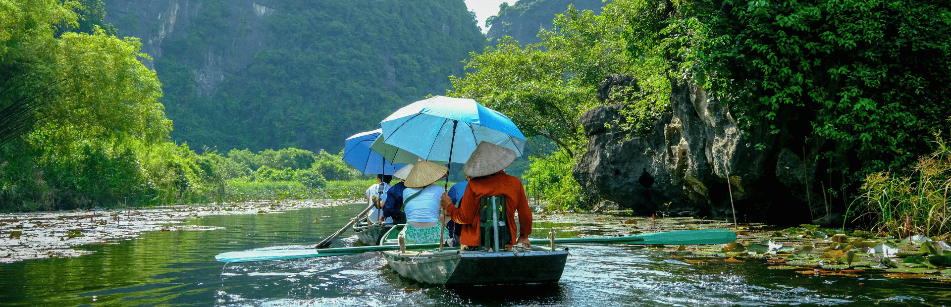 Touristen auf einem Ruderboot in der Trockenen Halong Bucht in Vietnam