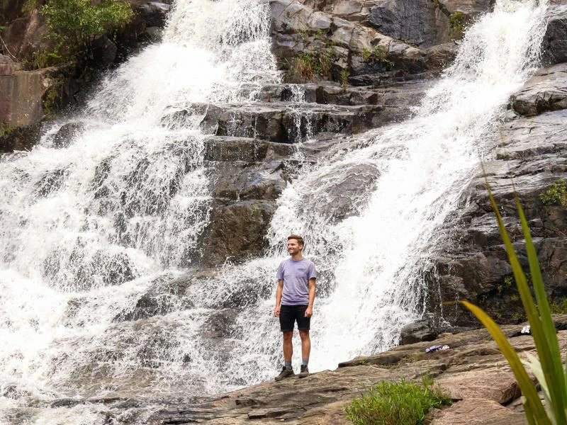 Tourist vor rauschendem Wasserfall in Vietnam