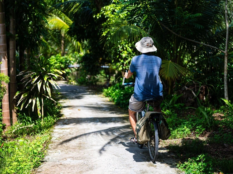 Vietnamese fährt auf einem Fahrrad durch das Mekongdelta in Vietnam