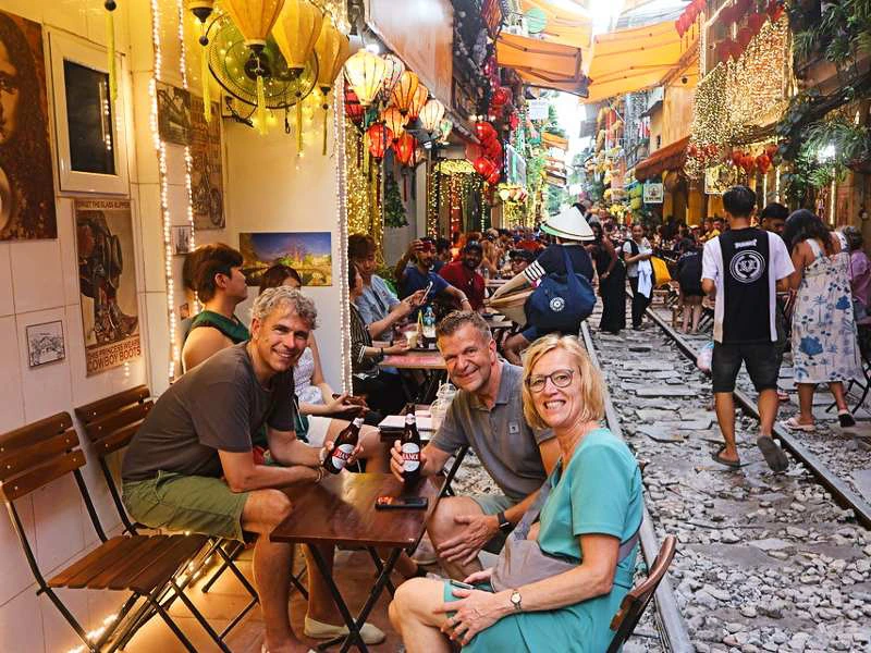 Touristen sitzen in einem Café an der Train Street im Old Quarter in Hanoi