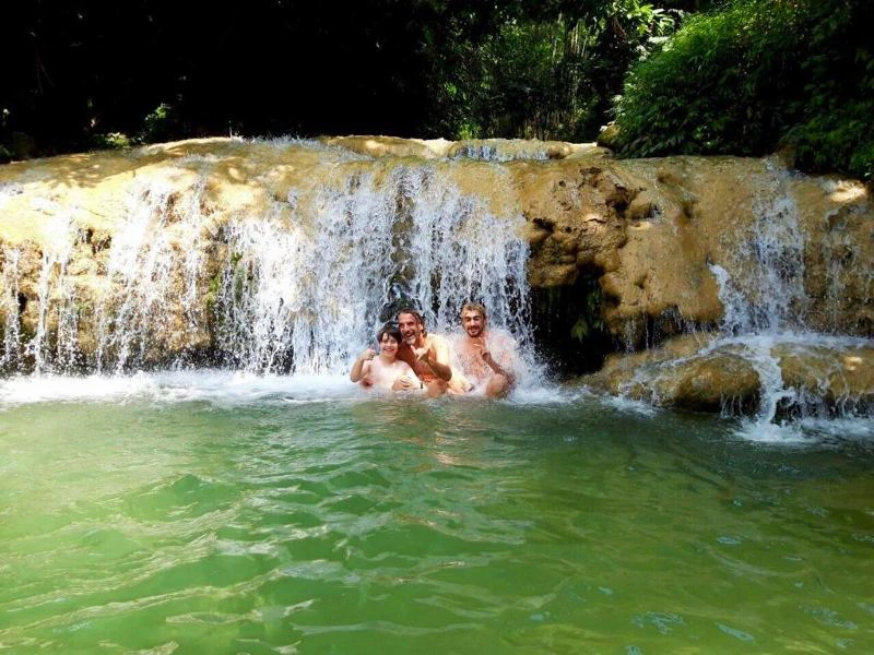 Touristen beim Baden unter einem Wasserfall in Pu Luong, Vietnam