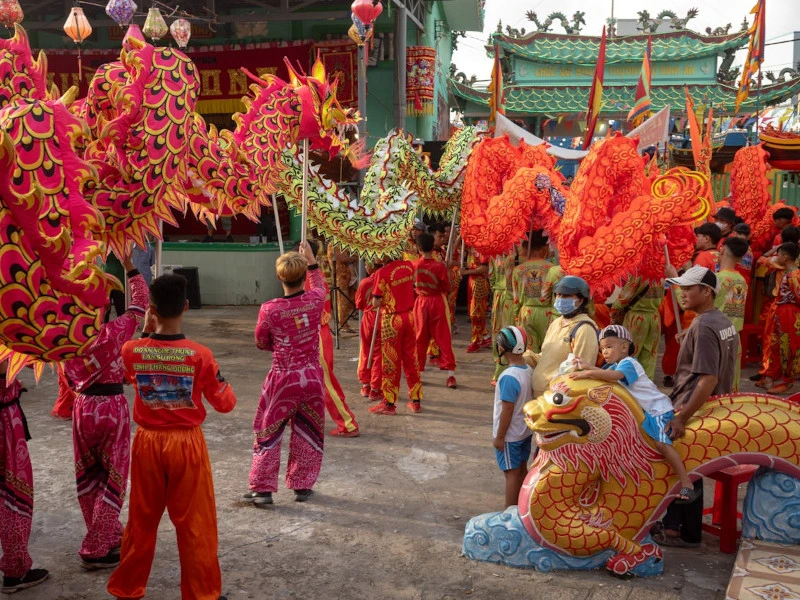 Farbenfrohe Drachenfiguren und Tänzer in traditionellen Kostümen