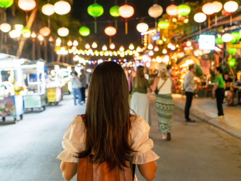 Tourist auf dem Nachtmarkt vor leuchtendem´n Lampions in Hoi An