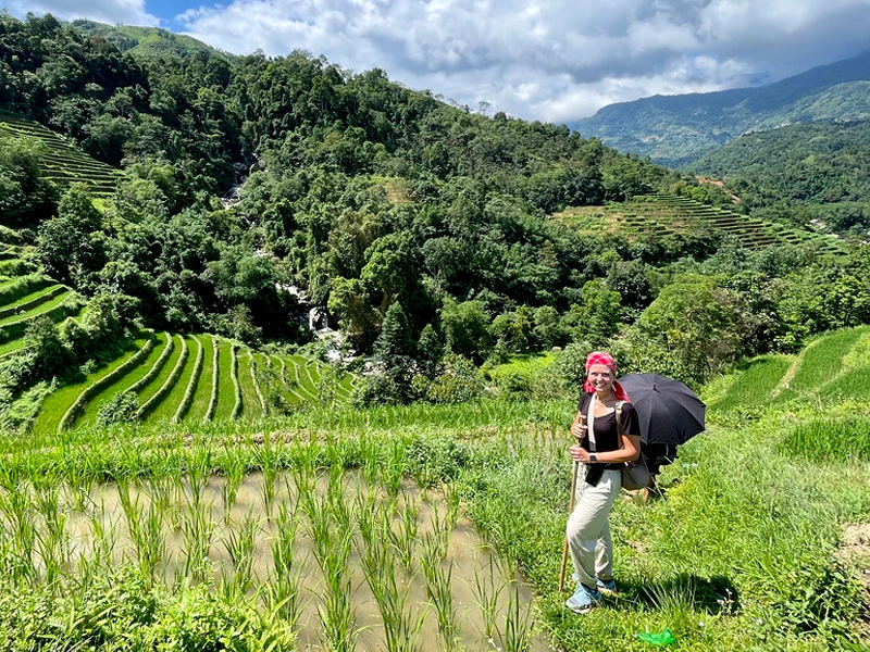 Frau wandert durch die Reisfelder in den Bergen