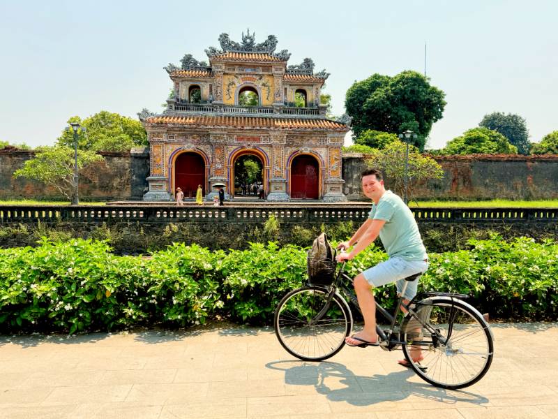 Tourist auf dem Fahrrad vor dem Kaiserpalast in Hue