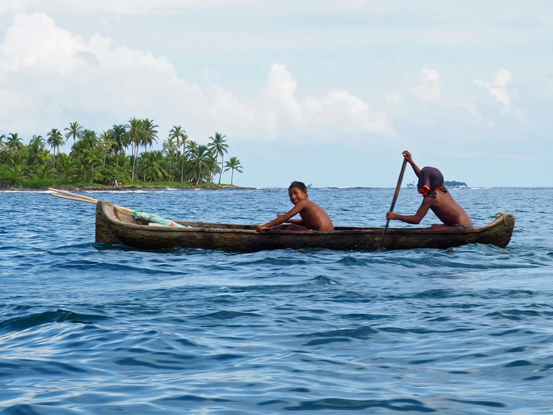 Einheimische auf einem Boot vor den San Blas Inseln in Panama