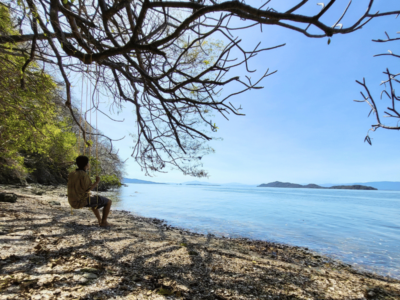 Mann auf Schaukel mit Blick auf den Nicoya Golf