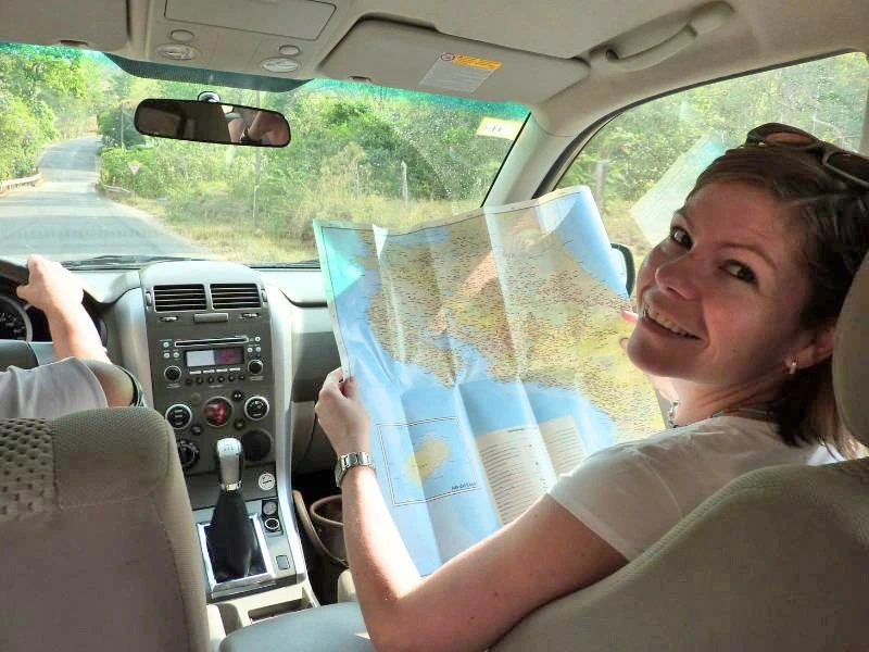 Frau schaut im Auto auf die Karte von Costa Rica