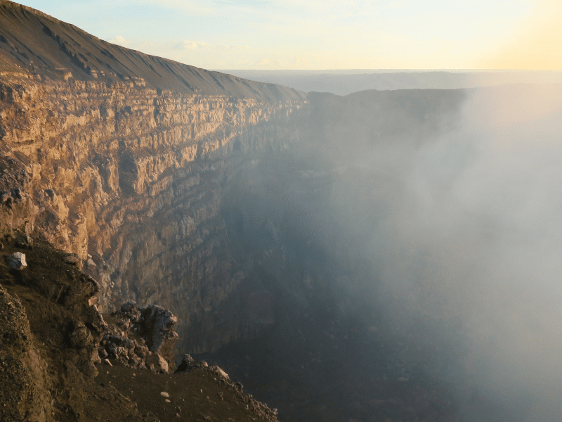Der dampfende Krater des aktiven Vulkans Masaya bei Sonnenuntergang, ein spektakuläres Naturphänomen, das Besucher in Staunen versetzt.