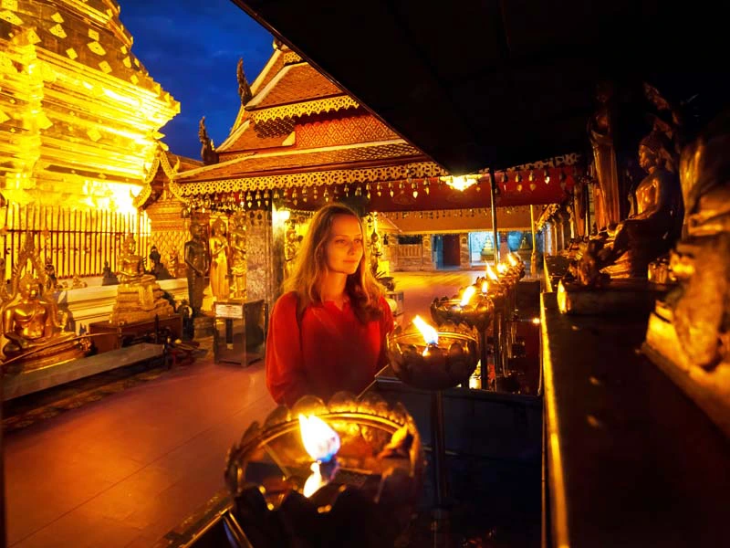 Tourist in einem bei Nacht beleuchteten Tempel in Chiang Mai Thailand