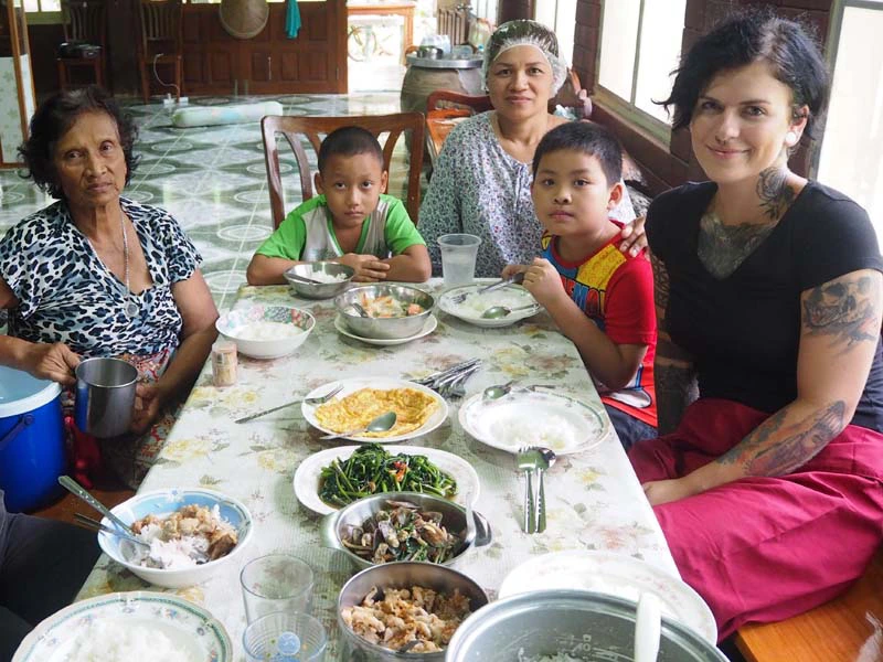 Tourist sitz mit Familie am Tisch beim Homestay in Thailand