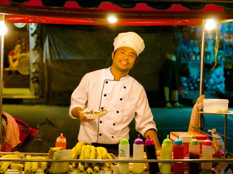 Koch an einer Garküche in Chiang Mai Thailand
