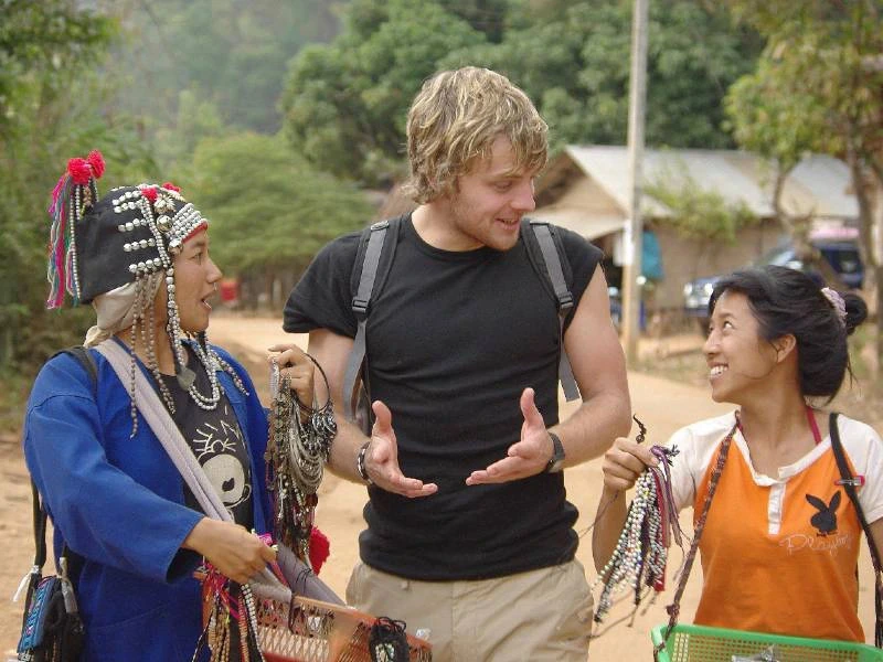 Tourist mit Einheimischen in einem Bergdorf in Thailand
