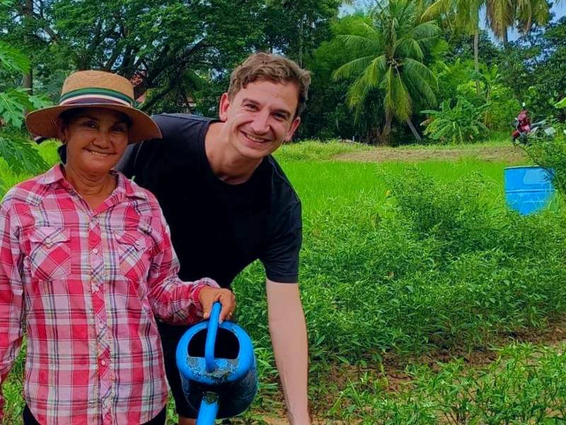 Tourist mit einem Einheimischen in einem grünen Garten in Thailand