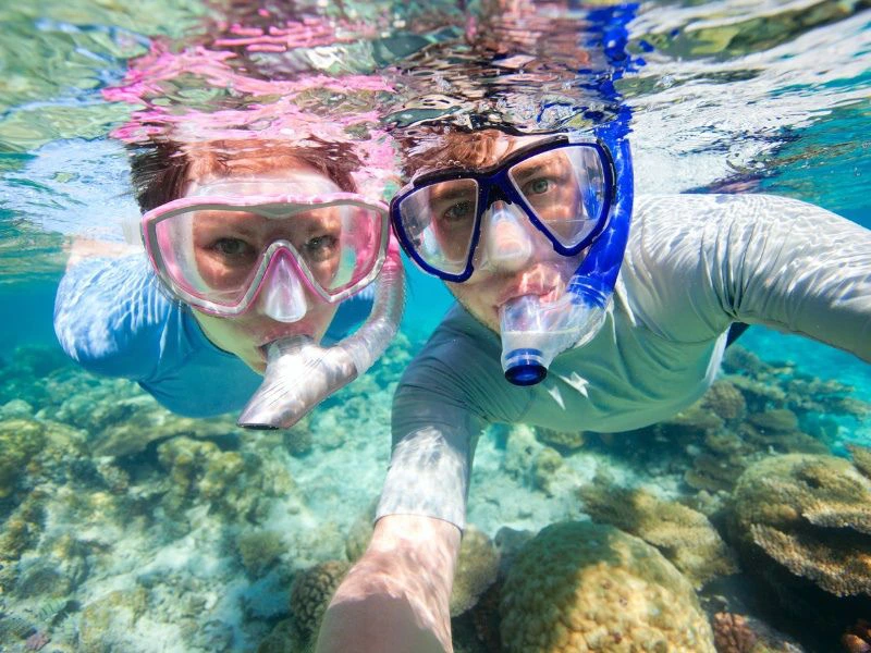 Touristen beim Schnorcheln im blauen Wasser in Thailand
