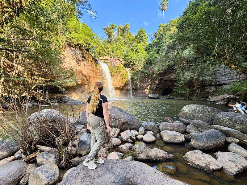 Frau vor Wasserfall im Khao Yai Nationalpark in Thailand