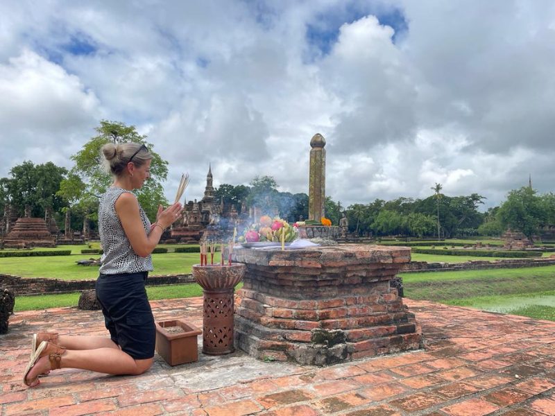 Touristin bei Opfergabe in Sukhothai, Thailand