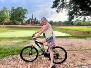 Touristin mit dem Fahrrad in der Tempelanlage in Sukhothai, Thailand