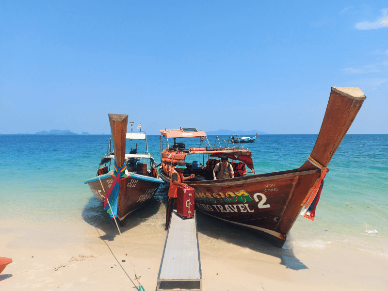 Boote entladen Gepäck bei Ankunft auf Koh Mook, Thailand
