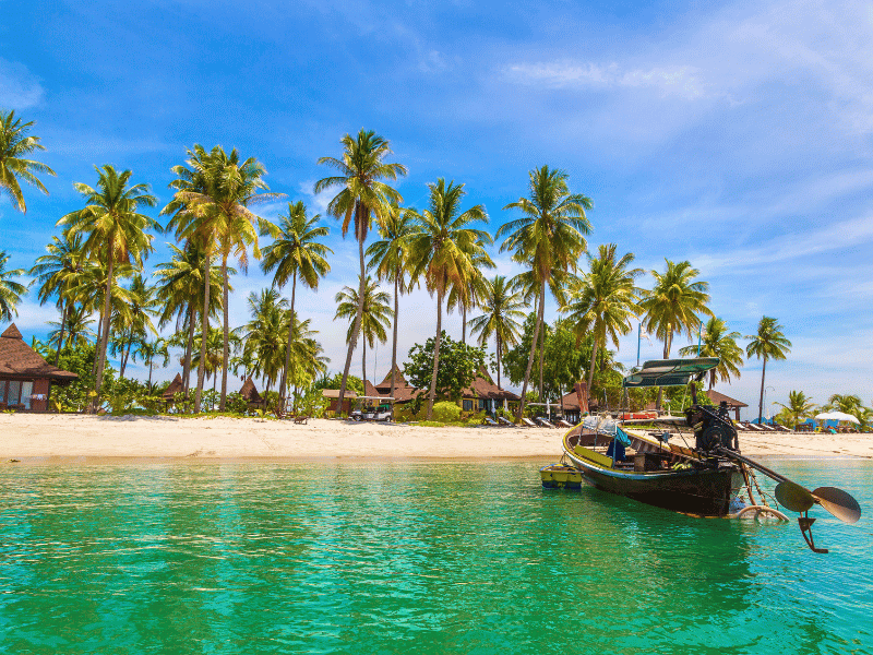 Boot liegt am palmengesäumten Strand von Koh Mook, Thailand