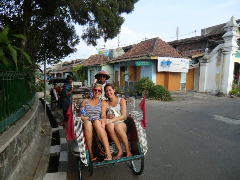 Touristen sitzen in einer Fahrradrikscha in Bandung