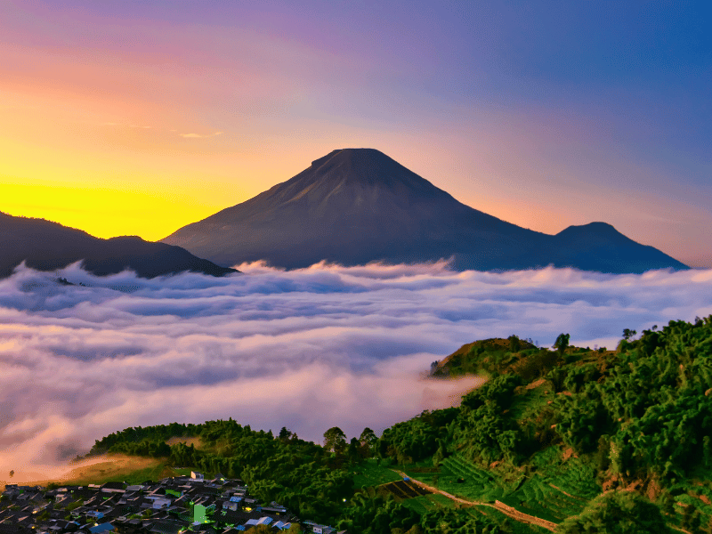 Panorama vom Vulkan und Bergdorf Wonosobo mit einer niedrigen Wolkendecke auf Java